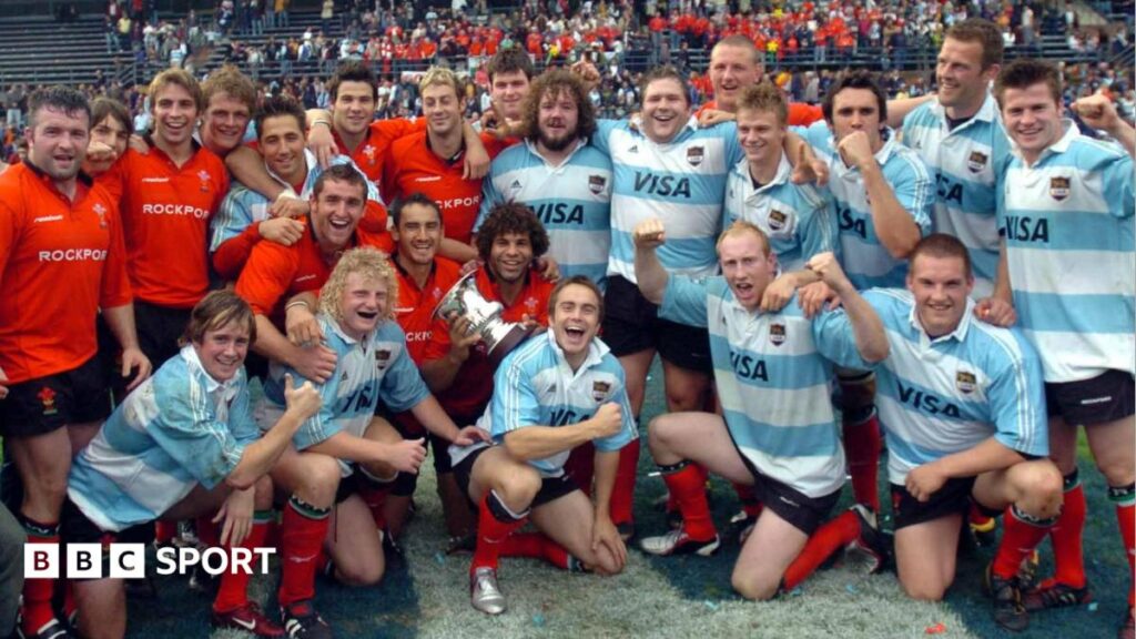 Wales players, some in red Wales shirts and some in blue and white Argentina jerseys, pose together on the pitch on the 2004 tour of Argentina.