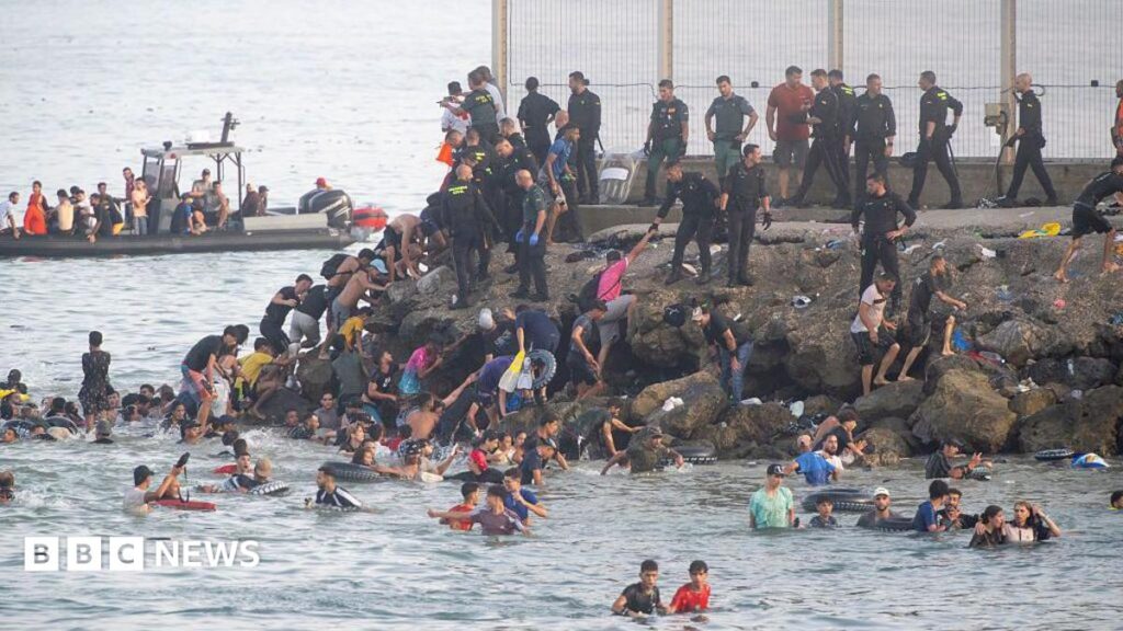 Dozens of migrants walking on a coastal path