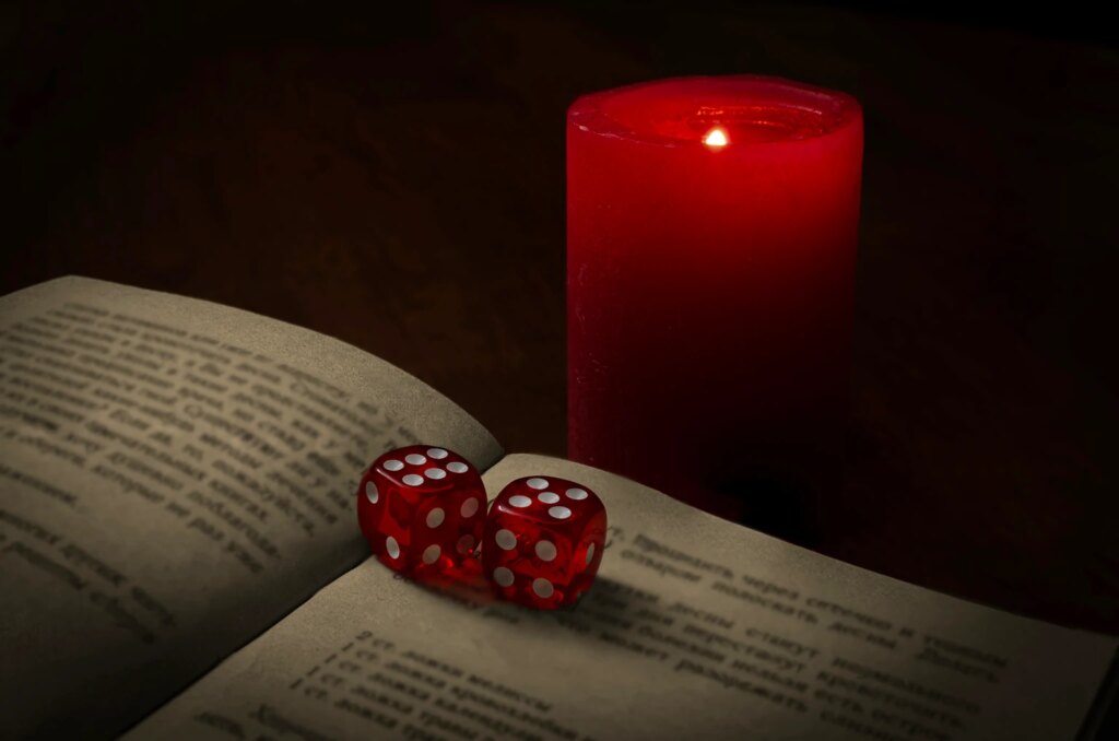 mystical scene with dice, book and candle