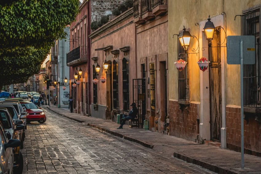 Finding home in Mexico, one ordinary day at a time Santiago de Querétaro street scene, with car pulling out from a narrow block filled with residential housing.