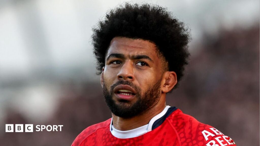 Head and shoulders view of Kallum Watkins in red England shirt